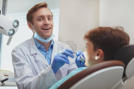 Téléchargez les photos : "Charmant jeune garçon se faire examiner les dents chez le dentiste" - en image libre de droit