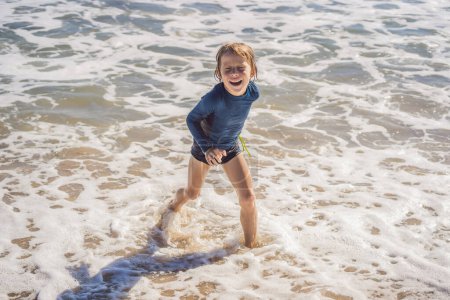 Foto de "Lindo niño divirtiéndose en la playa tropical durante las vacaciones de verano
" - Imagen libre de derechos