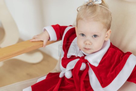 Foto de Child girl dressed in Christmas dress with cochlear implants having fun at home - diversity and hearing aid and innovating technologies for treatment of deafness - Imagen libre de derechos