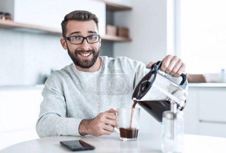 Foto de Atractivo hombre vertiendo a sí mismo una taza de café de la mañana - Imagen libre de derechos