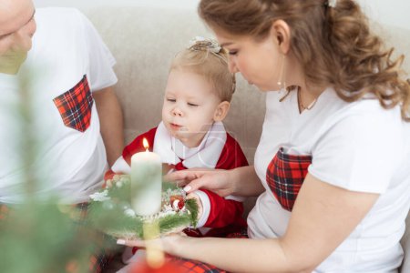 Foto de Baby child with hearing aid and cochlear implant having fun with parents in Christmas room. Deaf , diversity and health concept - Imagen libre de derechos