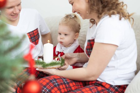 Foto de Baby child with hearing aid and cochlear implant having fun with parents in Christmas room. Deaf , diversity and health concept - Imagen libre de derechos