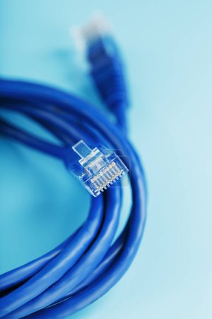 Foto de "A coil of an Internet network cable for data transmission on a blue background" - Imagen libre de derechos