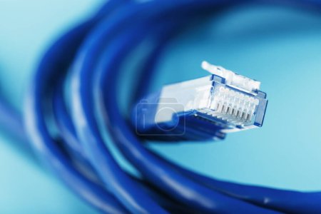 Foto de "A coil of an Internet network cable for data transmission on a blue background" - Imagen libre de derechos