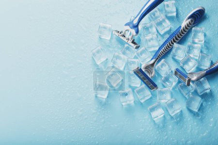 Foto de "Three shaving machines on a frosty blue background with ice. The concept of cleanliness and frosty freshness" - Imagen libre de derechos