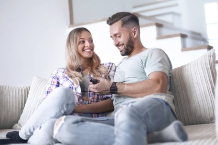 Photo for "loving couple sitting on sofa in cozy living room" - Royalty Free Image