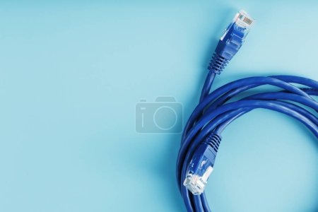 Photo for "A coil of an Internet network cable for data transmission on a blue background" - Royalty Free Image