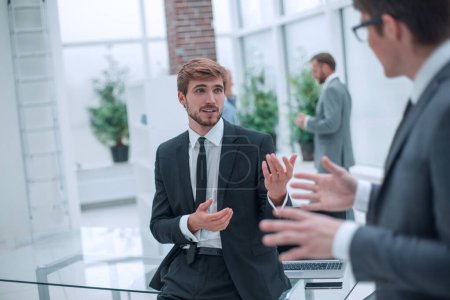 Photo for Employees discuss their ideas standing in the office lobby - Royalty Free Image