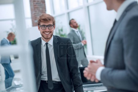Foto de Sonrientes hombres de negocios hablando con su colega - Imagen libre de derechos