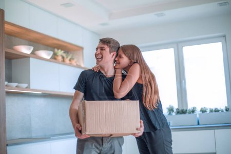 Photo for "happy young couple with cardboard box standing in kitchen" - Royalty Free Image