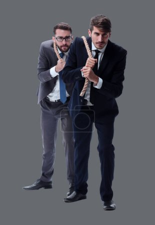 Foto de Longitud total. dos hombres de negocios tirando de una cuerda larga. - Imagen libre de derechos