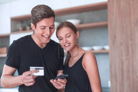 Téléchargez les photos : Jeune couple utilise un smartphone pour faire du shopping en ligne. - en image libre de droit