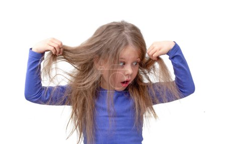Photo for "Child holding hair being in shock about hair loss" - Royalty Free Image