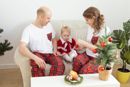 Photo for Child with cochlear implant hearing aid having fun with parents in Christmas living room - diversity , deafness treatment and medical innovative technologies - Royalty Free Image
