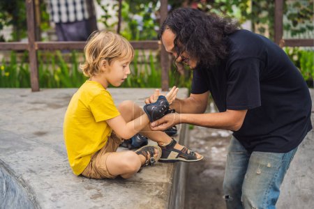 Photo for Trainer helps the boy to wear knee pads and armbands before training skate board - Royalty Free Image