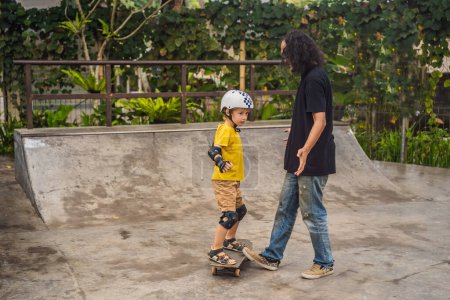 Foto de "Athletic boy aprende a patinar con un entrenador en un parque de skate. Educación infantil, deportes
" - Imagen libre de derechos