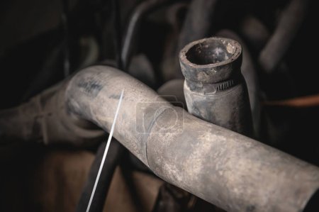 Photo for "Rubber pipes and hoses leading from the car radiator to the engine, view of the engine from below. old worn rubber car cooling system hoses" - Royalty Free Image