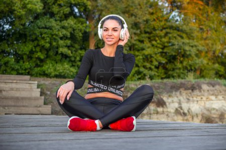 Photo for Beautiful sporty girl listens to music - Royalty Free Image