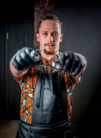 Photo for Professional tattooist with a tattoo gun in tattoo studio - Royalty Free Image