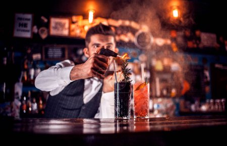 Téléchargez les photos : Professionnel Femme barman termine intensément sa création à la boîte de nuit - en image libre de droit