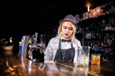 Photo for Confident girl bartender pouring fresh alcoholic drink into the glasses at bar - Royalty Free Image