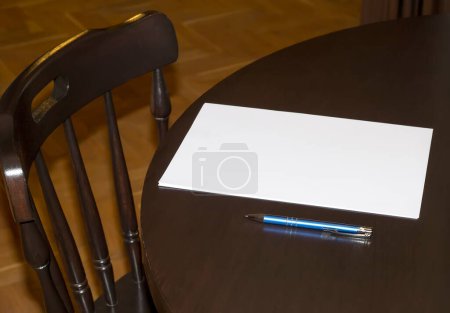 Téléchargez les photos : Papier blanc avec un stylo sur la table à la maison. Vue latérale - en image libre de droit