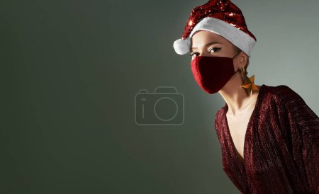 Photo for Woman with red christmas hat, red medical mask. Fashion shiny style for xmas time. Protection from flu on holidays - Royalty Free Image