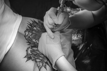 Photo for Skin master creates a tattoo his salon - Royalty Free Image