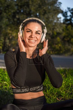 Foto de Linda chica deportiva escuchando música con auriculares - Imagen libre de derechos