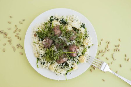 Photo for Swedish meatballs with dill, topped with celery and spinach rice. Cooking at home, home-cooked food. - Royalty Free Image