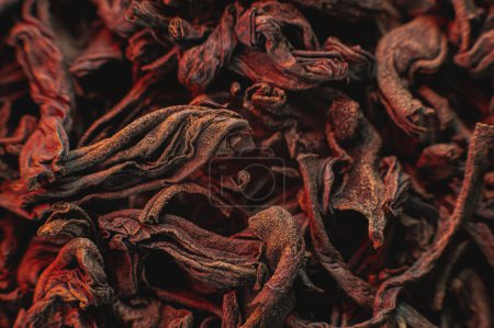 Foto de Té negro de hojas sueltas sobre una luz roja como fondo. Textura de hojas secas de té negro. Fondo oscuro. Modo macro extremo. té de hoja negra primer plano - Imagen libre de derechos