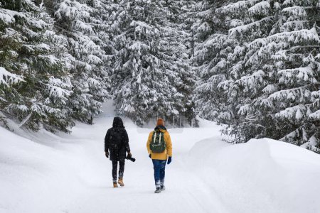 Téléchargez les photos : Deux photographes parcourent les montagnes hivernales - en image libre de droit