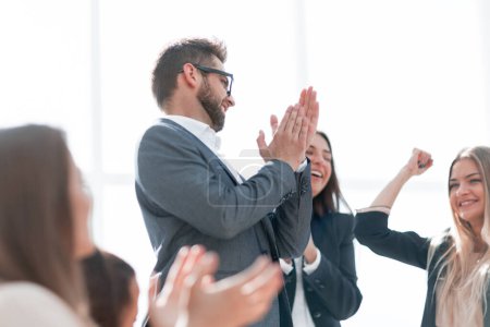 Photo for Happy group of employees applauds standing in the office - Royalty Free Image