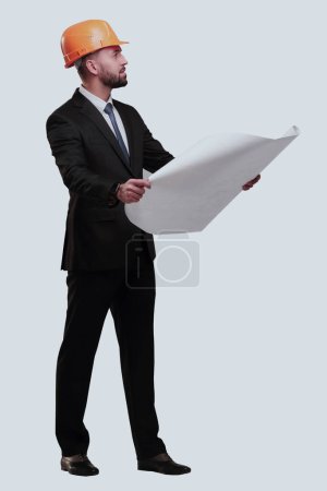 Foto de Hombre de negocios con casco mirando nuevos dibujos. aislado en blanco - Imagen libre de derechos