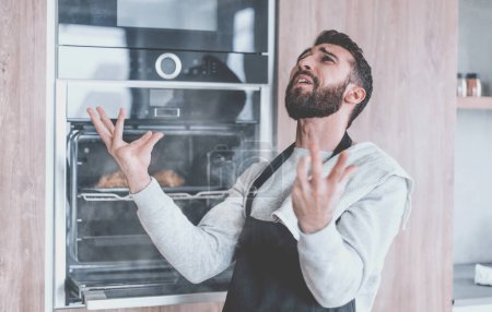 Photo for Surprised man standing near the oven with burnt croissants. - Royalty Free Image