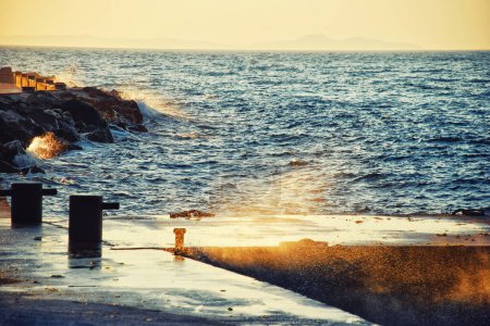 Photo for "Seashore dock at sunset with waves" - Royalty Free Image