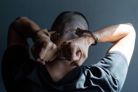 Téléchargez les photos : Male hands in handcuffs black background - en image libre de droit