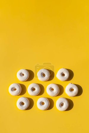 Foto de Rosquillas blancas en forma de corazón sobre un fondo amarillo. - Imagen libre de derechos