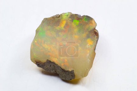 Raw sin cortar brillante blanco colorido piedra de cristal de ópalo etíope primer plano macro aislado en una superficie blanca 