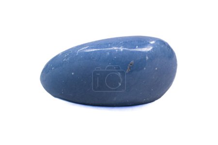 Foto de Cristal de angelita azul claro macro, piedra de anhidrita azul tumbada brillante aislada sobre un fondo de superficie blanca - Imagen libre de derechos