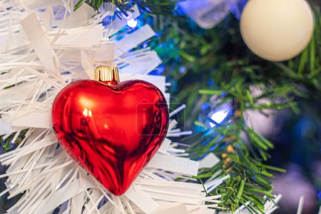 Foto de Heart Christmas ornament on white fluffy decoration positioned on left side with place for copy space on left - Imagen libre de derechos