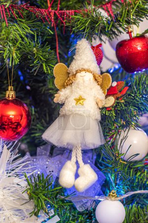 Foto de White fairy ornament with golden winds isolated on Christmas tree with others Christmas ornaments backdrop - Imagen libre de derechos