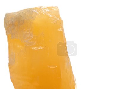 Foto de Macro focused raw shiny semi-transparent vibrant orange, calcite stone, bright orange carbonate crystal isolated on a white surface background - Imagen libre de derechos