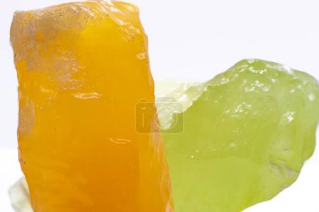 Foto de Macro focused raw shiny semi-transparent vibrant orange and pistachio lime green calcite mineral, calcite stone, two bright carbonate crystals isolated on a white surface background - Imagen libre de derechos