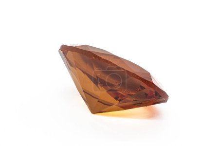 Colour changing diaspore, Turkish Zultanite oval faceted on white background under white artificial light. Yellow to orange color shift zultanite.