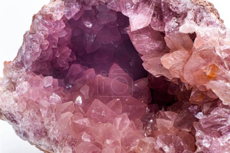 Macro focused vibrant pink amethyst quartz geode crystal, rose hematite amethyst points isolated on a white background surface