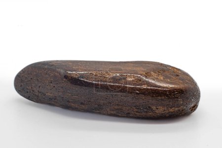 Macro Focused Tumbled Dark brown and shiny bronze bronzite stone polished crystal isolated on a white surface background 
