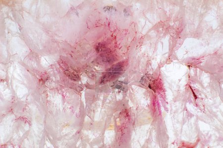 Weißer, dunkler und hellorangefarbener und roter Scheibenkristall aus Achat, gebänderter Chalcedon-Stein isoliert auf einer weißen Hintergrundoberfläche mit Details. Abstraktes Kristallbild mit viel Kopierraum