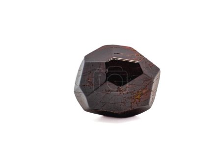 Dodekaedrisches natürliches tiefrotes Granat, leicht getrommelt, polierter Kristall isoliert auf einer weißen Oberfläche, Hintergrund Makrofotografie