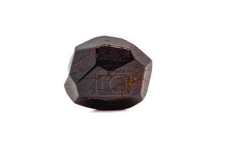 Dodecahedral natural deep red garnet lightly tumbled polished crystal isolated on a white surface background macro photography